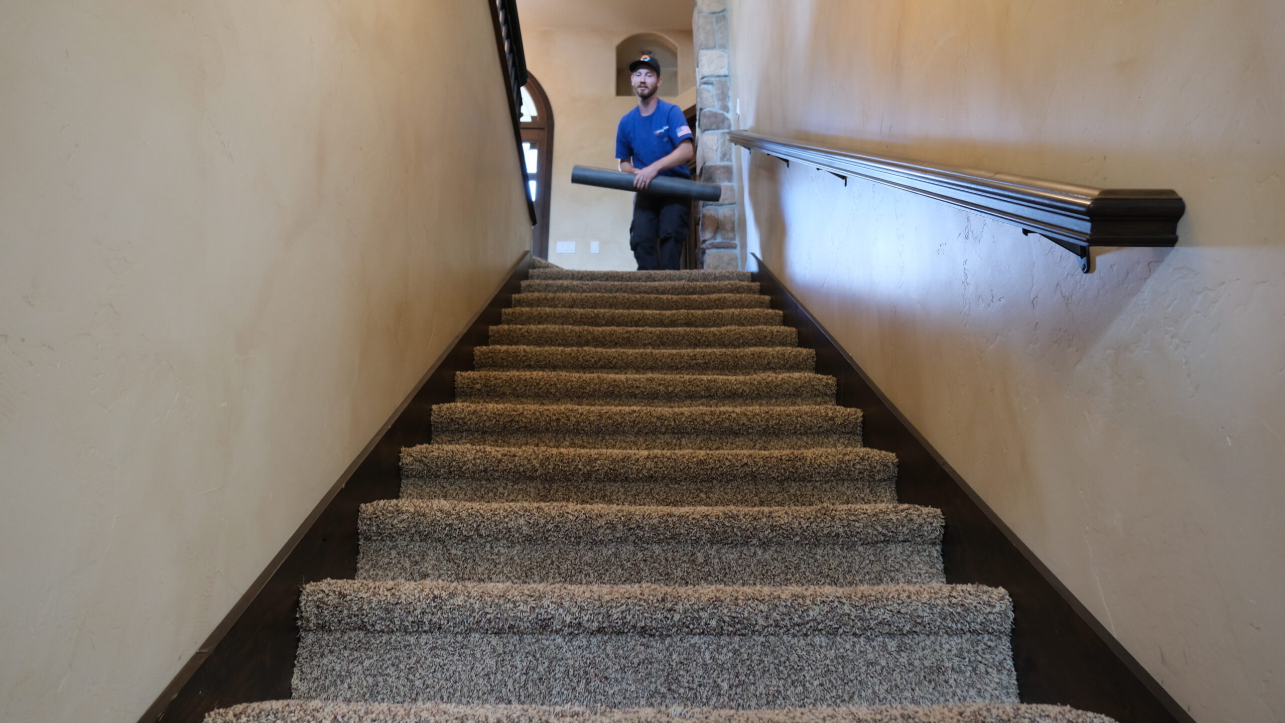 Brigham Heating and Cooling worker on staircase